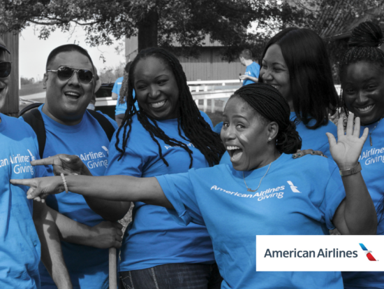 Group of people posing and smiling in blue t-shirts in support of inclusion for adults with autism