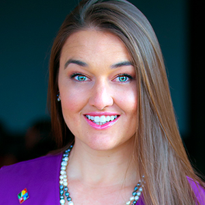 Woman with long brown hair smiles at the camera