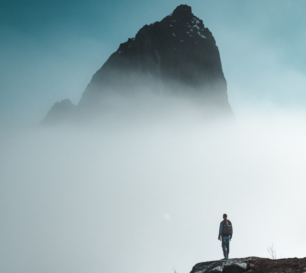 Man standing outdoors looking at tall mountain barriers