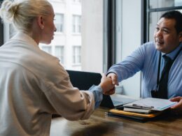 Two people shaking hands in a business office.