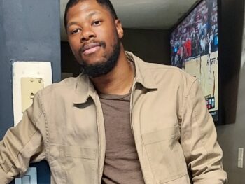 Picture of artist Jon-Keith Gary wearing a light tan jacket and a light brown shirt.