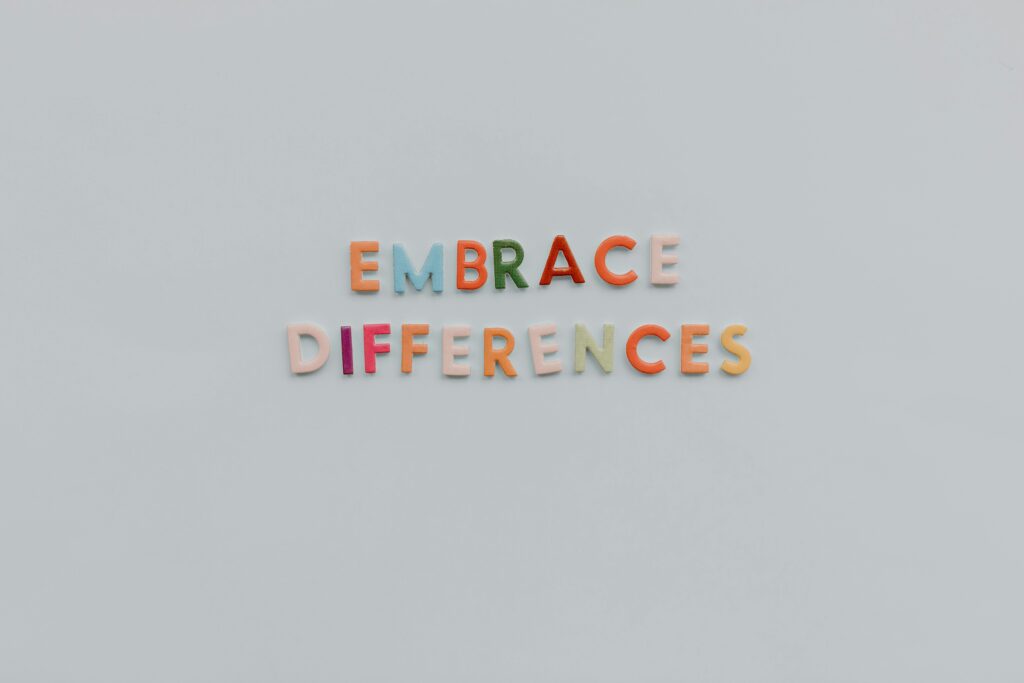 rainbow letter blocks that spell out "embrace differences" on a grey background