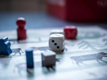 Close view of a board game with die and game pieces on top of a board