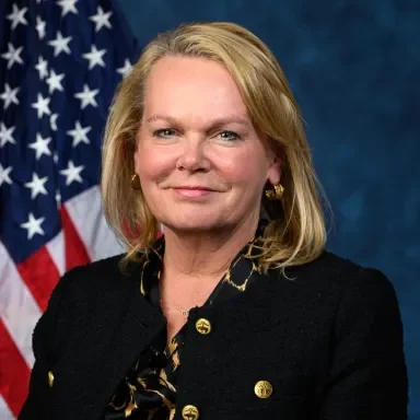 Person with shoulder length blonde hair looks at camera